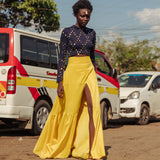 Model walking in bright yellow tiered cotton maxi skirt with thigh-high slit