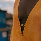 Artisan hand-cast brass hardware and turmeric-dyed cotton fabric on LilaBare kaftan tunic