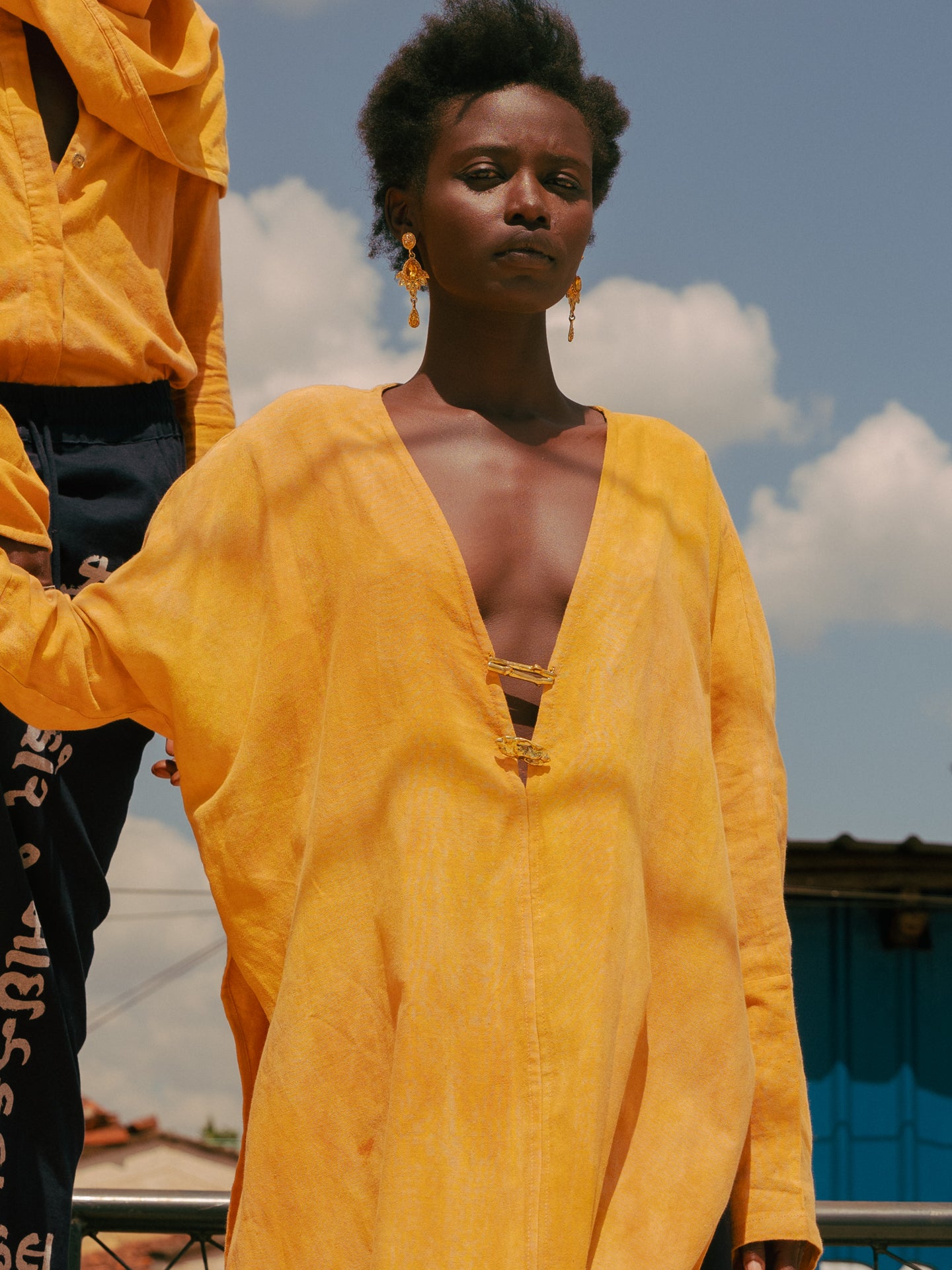 Close-up of plunge neckline and brass closures on LilaBare’s naturally dyed kaftan tunic