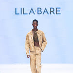 Model wearing marbled safari jacket in natural ochre tie-dye on runway