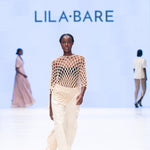 Runway LilaBare model wearing hand-crocheted cotton bolero mid-movement, capturing fishnet crochet and fluid silhouette