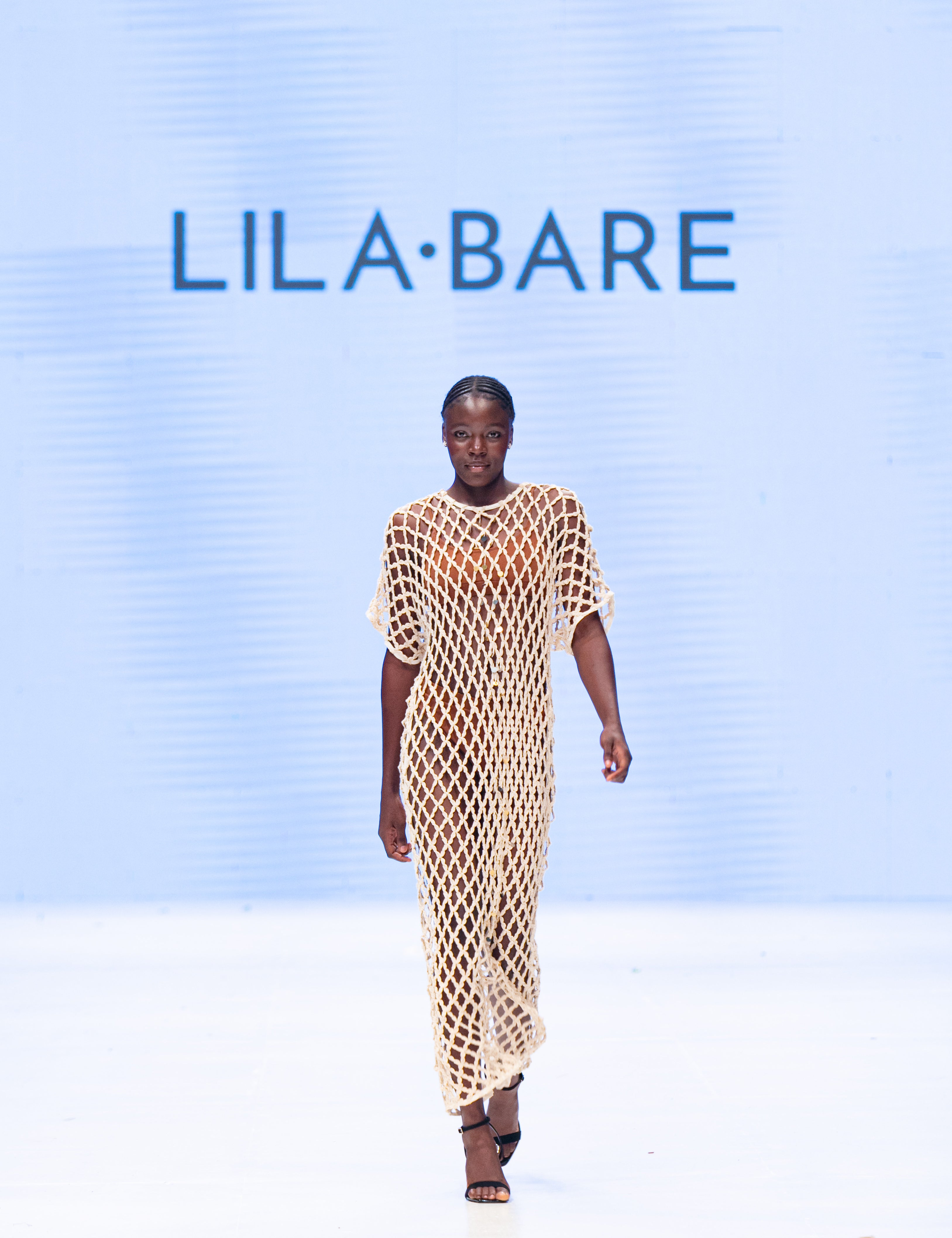 Model wearing handmade crochet dera dress by African designer brand LilaBare — featuring hand-beaded sequins and artisan craftsmanship