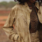 Closeup of handmade luxury leather and bead halter by LilaBare styled with jacket on model in nature