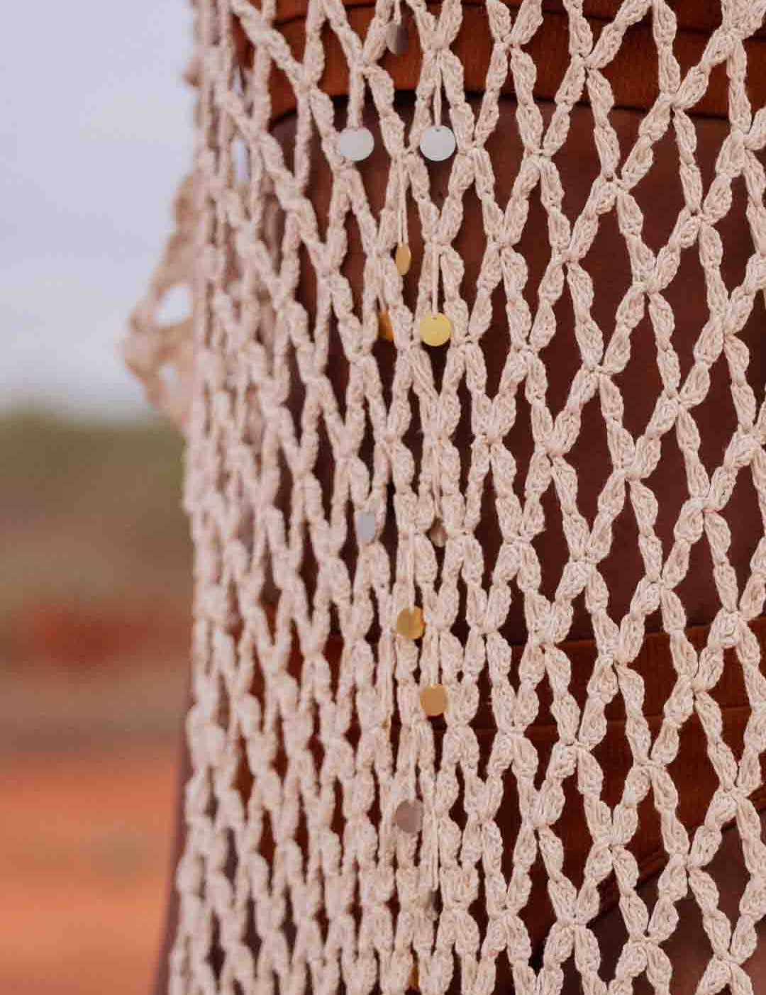 close up of Model wearing handmade crochet dera dress by African designer brand LilaBare — featuring hand-beaded sequins and artisan craftsmanship