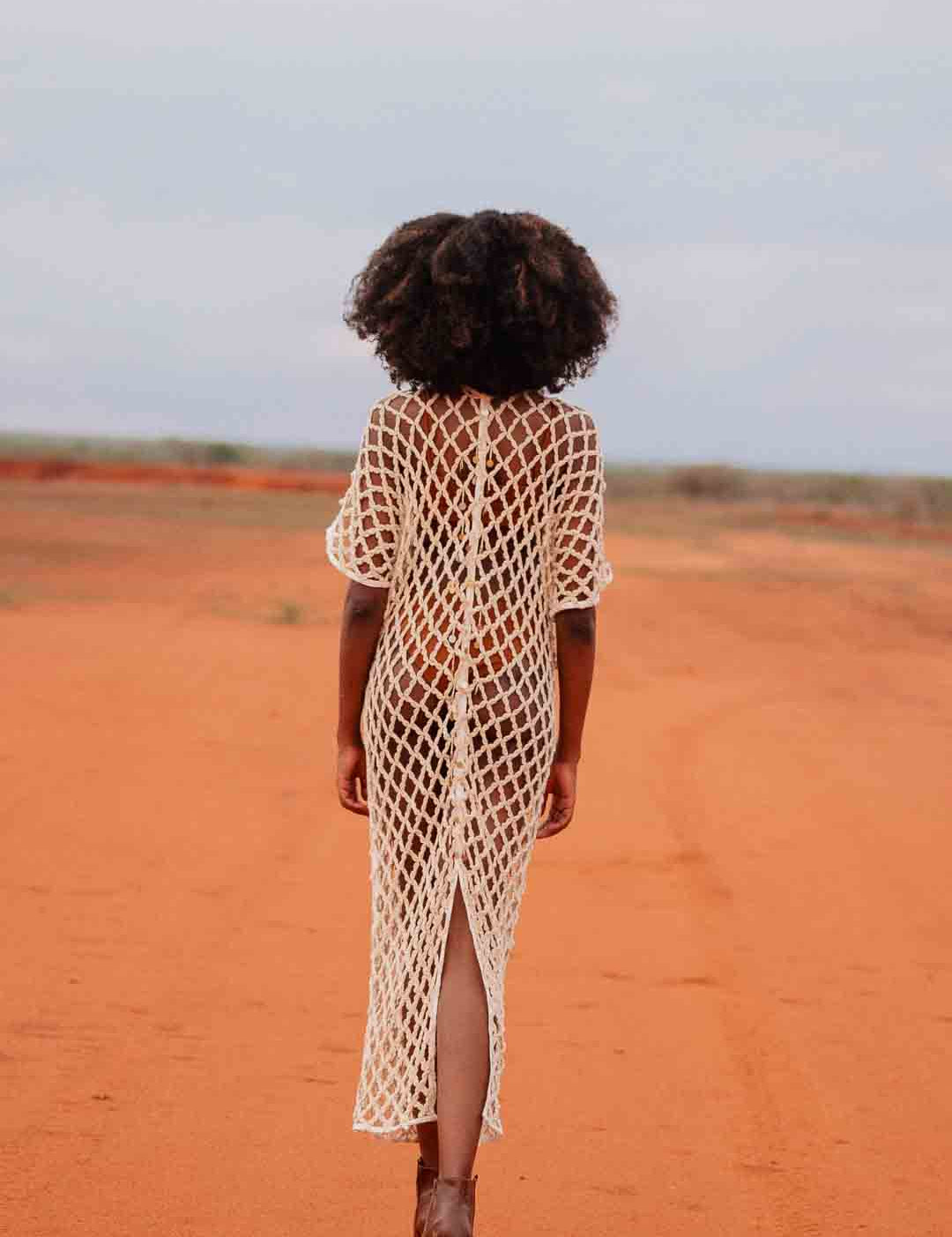 Back view of model wearing handmade crochet dera dress by African designer brand LilaBare — featuring hand-beaded sequins and artisan craftsmanship