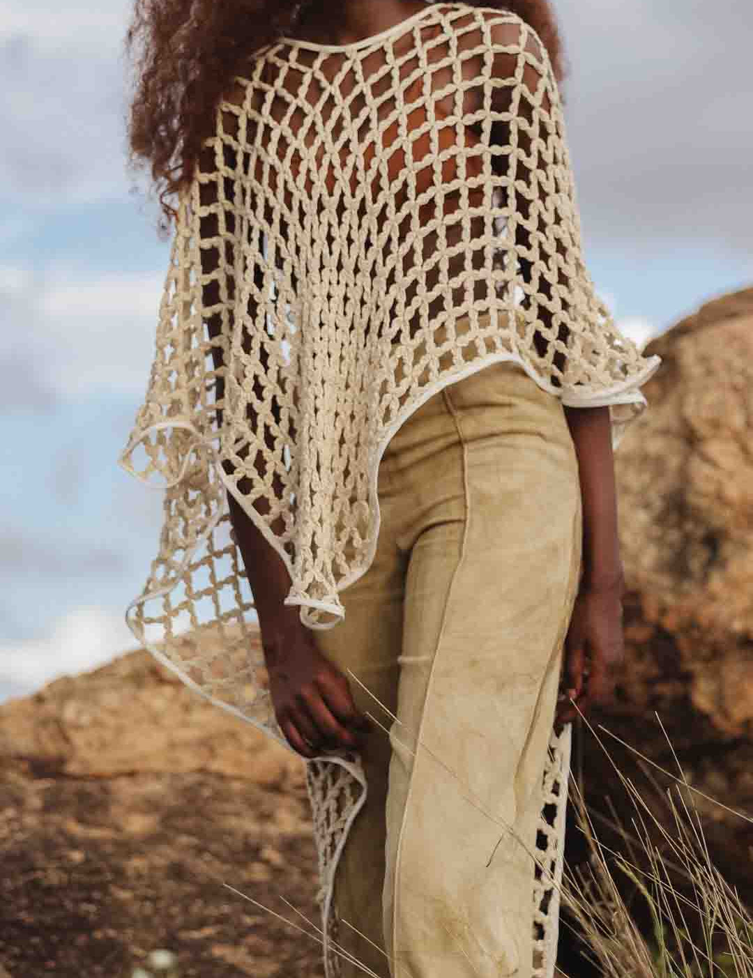 LilaBare model wearing hand-crocheted bolero mid-movement, capturing fishnet crochet and fluid silhouette