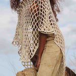 Side view of LilaBare model wearing hand-crocheted cotton bolero mid-movement, capturing fishnet crochet and fluid silhouette