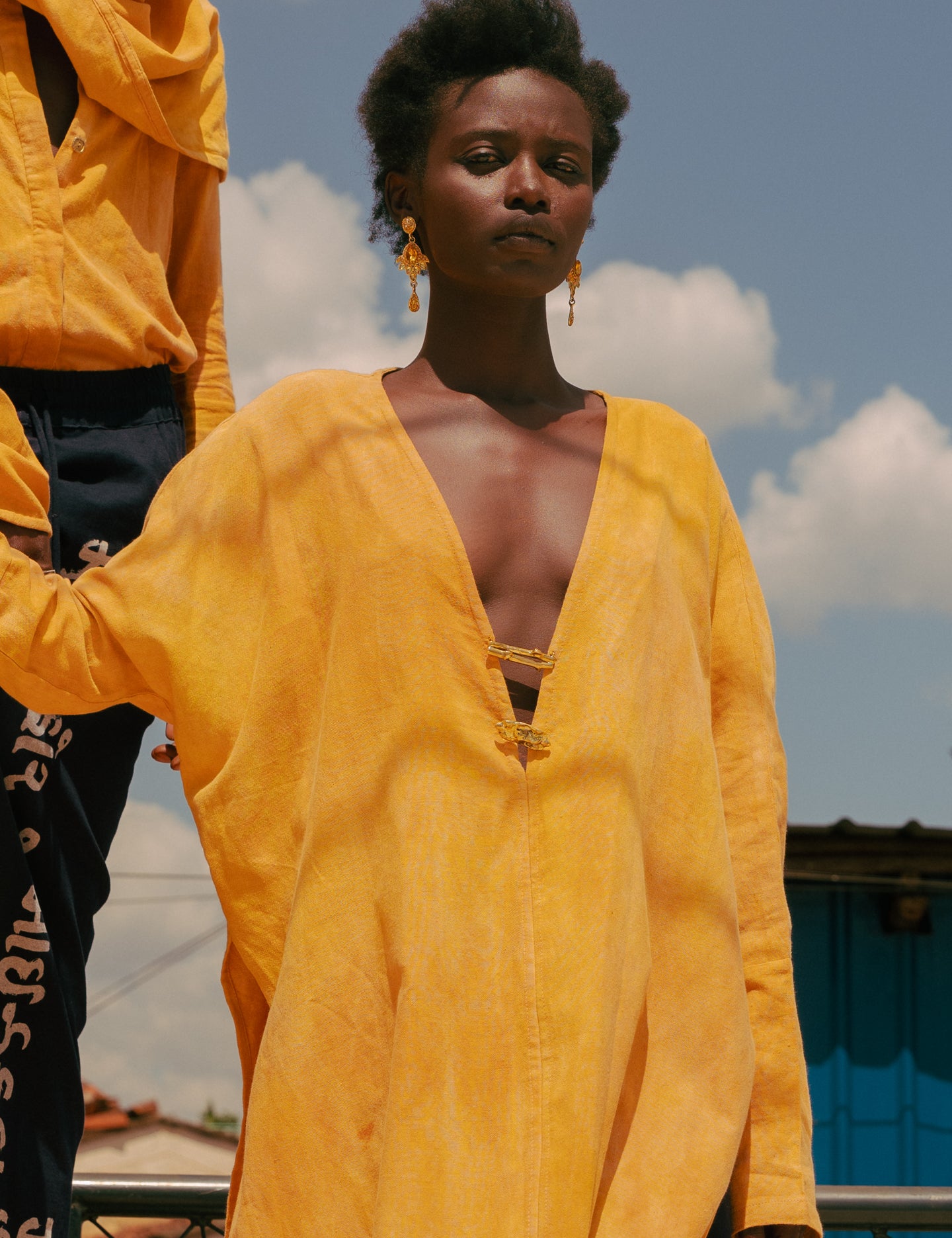 Close-up of plunge neckline and brass closures on LilaBare’s naturally dyed kaftan tunic