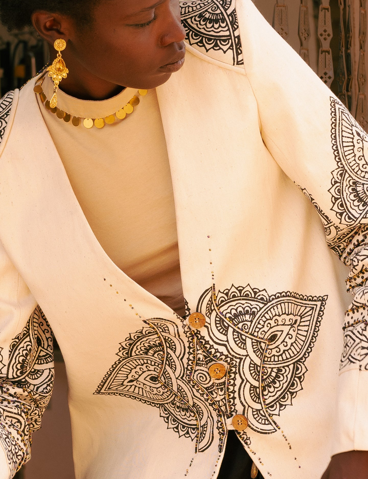 Close-up of choker-style upcycled brass sequin detail on cotton jersey