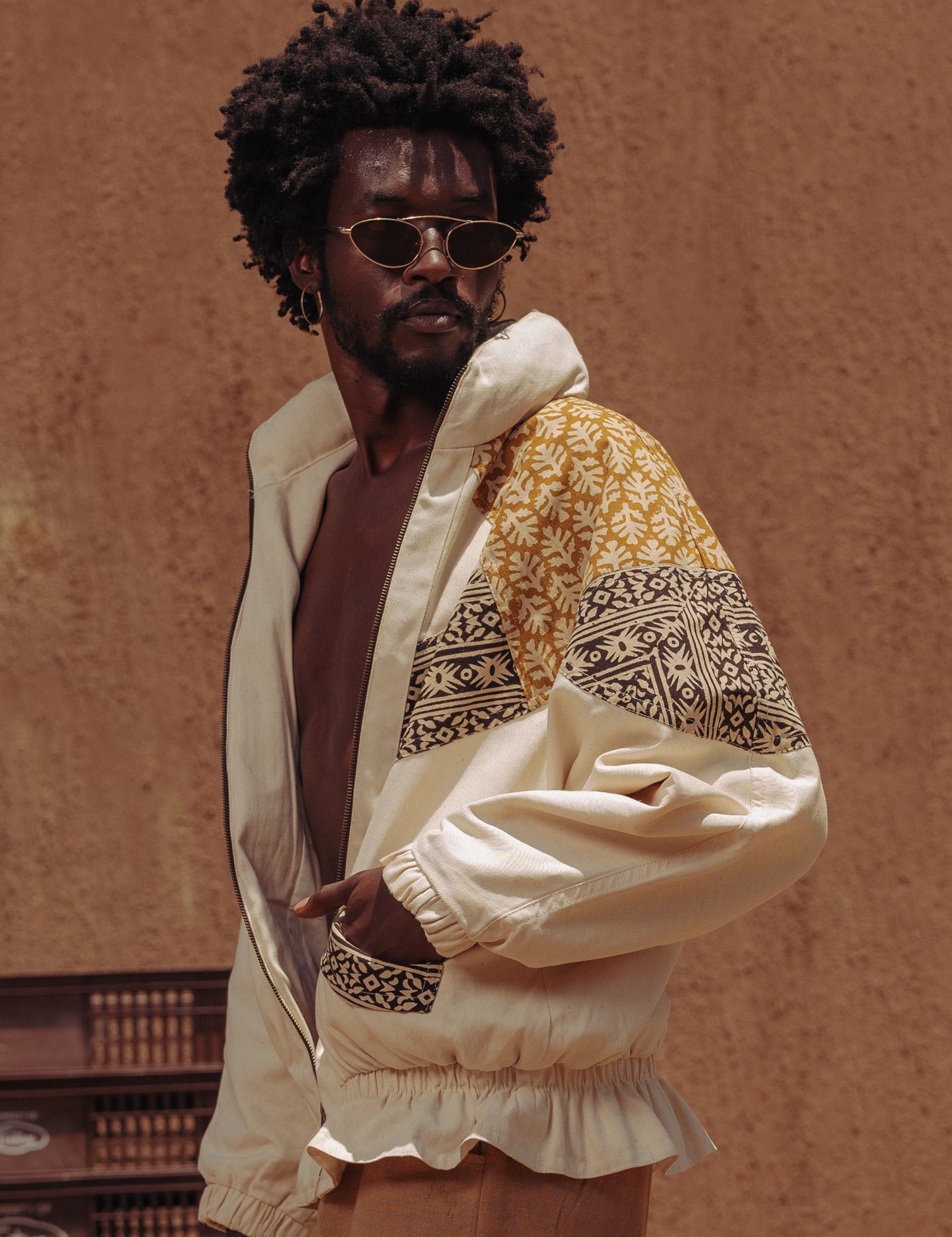 Model in hand-blockprinted oversized jacket in black and turmeric hues, ethically made in Kenya by LilaBare