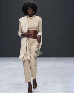 Front view of runway model wearing LilaBare’s Choker Crop Top with hand-applied brass sequin neckline layered with scarf