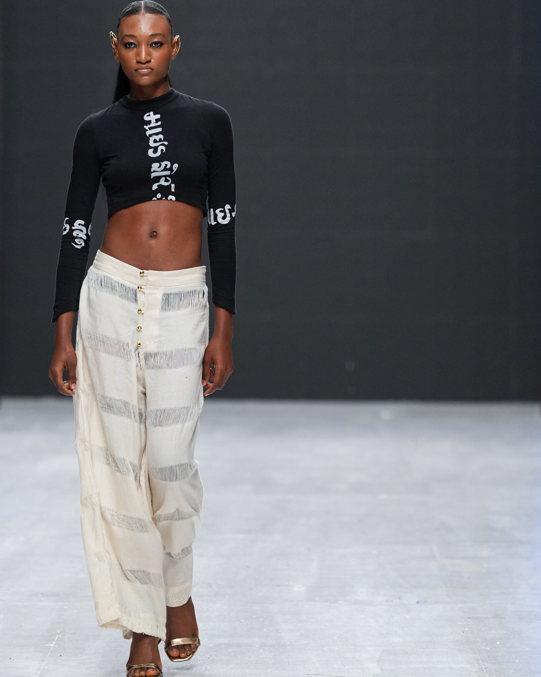 Model walking runway in LilaBare's shaggy handloom pants and black cropped top