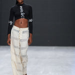 Model walking runway in LilaBare's shaggy handloom pants and black cropped top