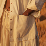 Close-up of LilaBare Shakti Shirt in natural cotton, showing natural button details and pockets.