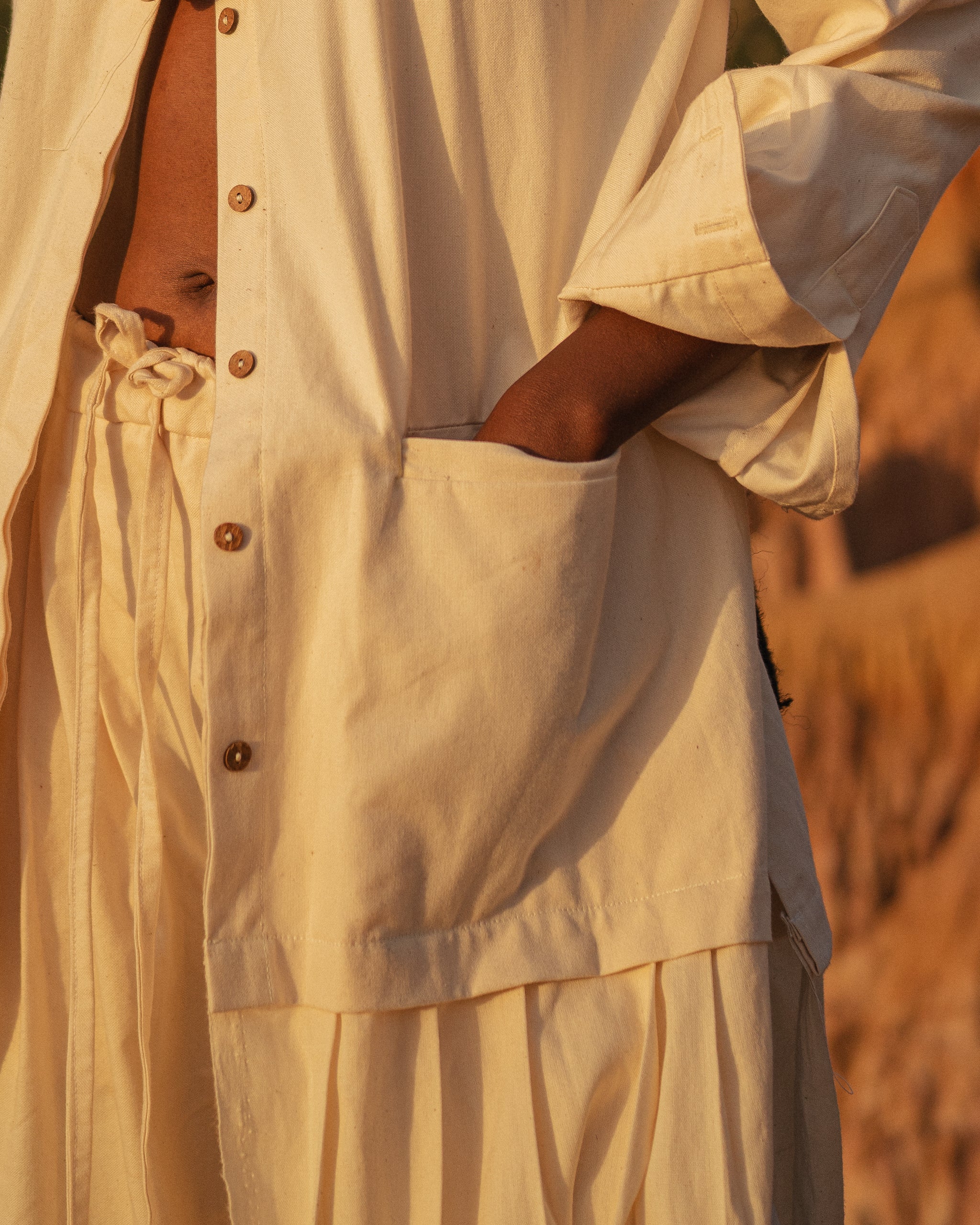 Close-up of LilaBare Shakti Shirt in natural cotton, showing natural button details and pockets.