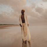 Model wears the Shakti Shirt and wide-leg pants in a sunlit natural setting, showcasing relaxed silhouette and gender-fluid style.